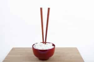 chopsticks placed vertically in a bowl of rice