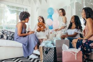 women give gifts to pregnant woman at baby shower