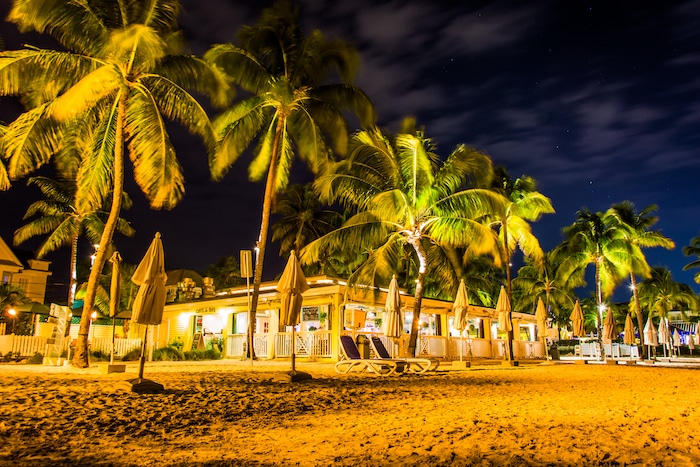 Palm trees and restaurant at night at South Beach, in Key West, Florida.