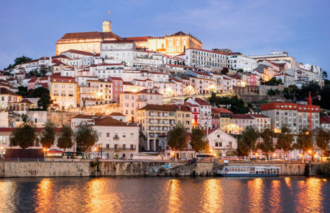 Beautiful and historic Coimbra cityscape with university at top of the hill in the evening, Portugal